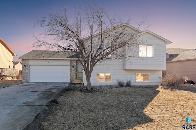 split level home featuring a garage and concrete driveway