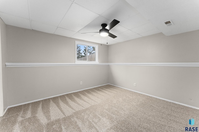 spare room featuring carpet, a paneled ceiling, visible vents, a ceiling fan, and baseboards