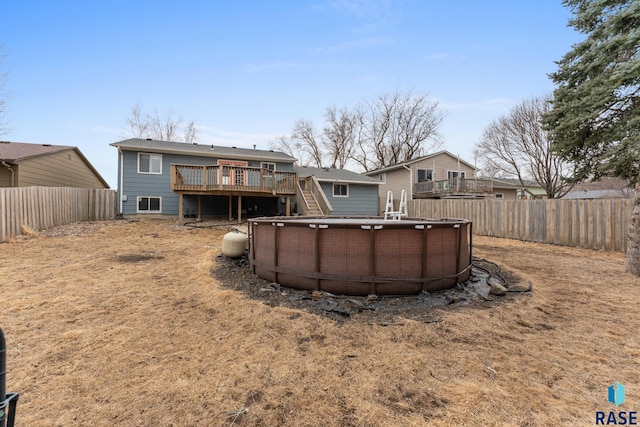 rear view of house featuring a fenced in pool, a fenced backyard, and a wooden deck