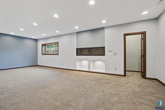 unfurnished living room featuring recessed lighting, visible vents, baseboards, and carpet