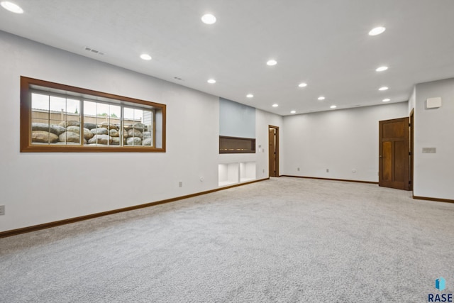 empty room with recessed lighting, visible vents, baseboards, and light colored carpet