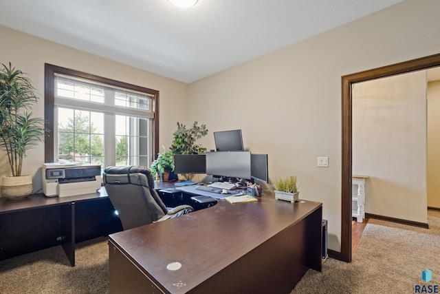 carpeted office space featuring baseboards