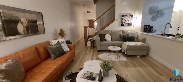 living room with stairway, baseboards, and wood finished floors