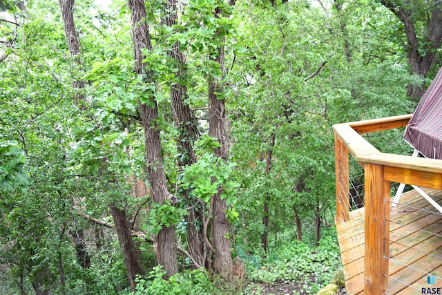 wooden terrace featuring a forest view