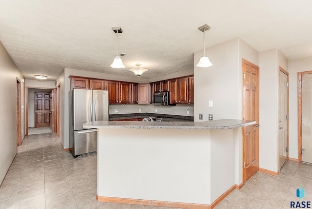 kitchen with decorative light fixtures, appliances with stainless steel finishes, a textured ceiling, a peninsula, and baseboards