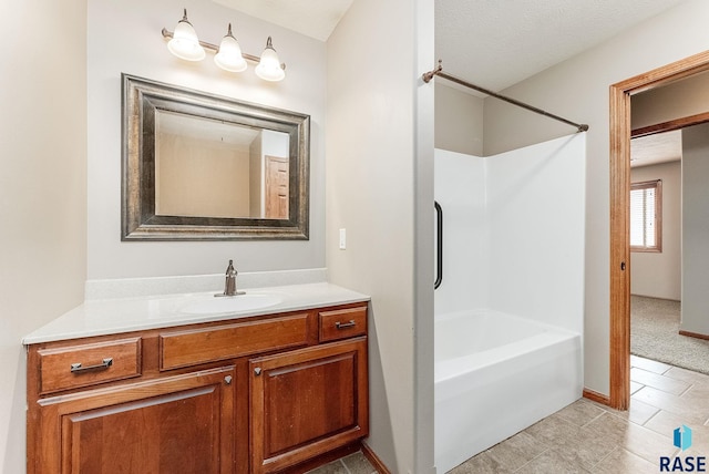 full bath with washtub / shower combination, baseboards, a textured ceiling, and vanity