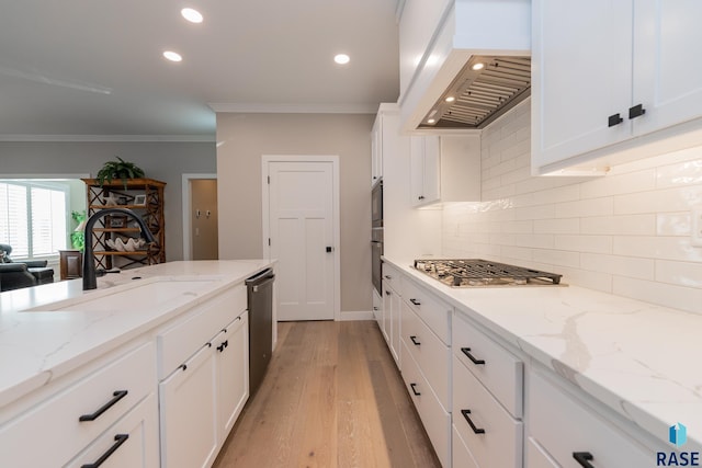 kitchen featuring custom exhaust hood, stainless steel appliances, crown molding, white cabinetry, and a sink