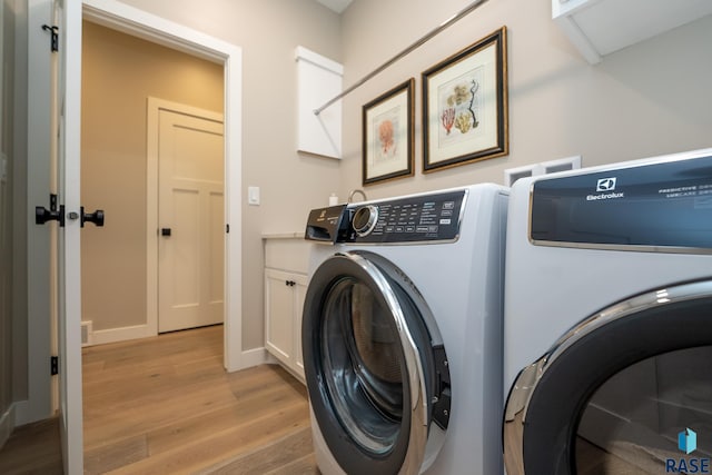 laundry area with washing machine and dryer, visible vents, baseboards, light wood-style floors, and cabinet space