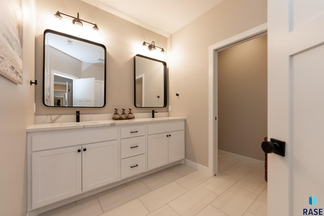 bathroom featuring tile patterned floors, a sink, baseboards, and double vanity