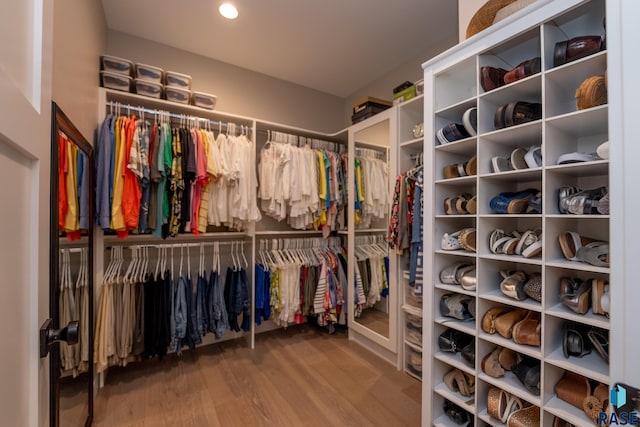 walk in closet with wood finished floors