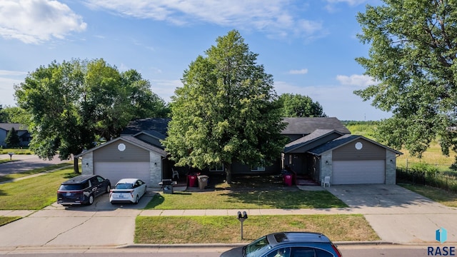 view of front of property with a garage, concrete driveway, and a front lawn