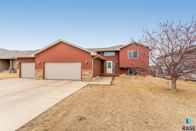 tri-level home with a garage and concrete driveway