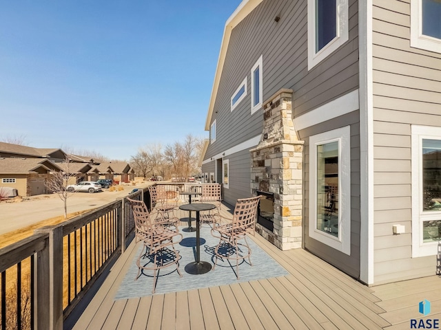 deck featuring outdoor dining area and a residential view