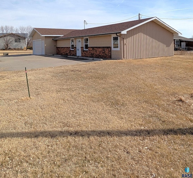 single story home featuring a garage and brick siding