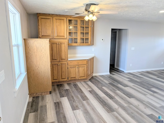 interior space with baseboards, brown cabinets, and a textured ceiling