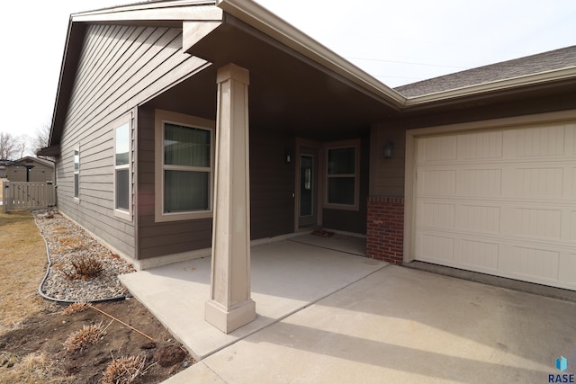 view of front facade featuring a garage, fence, and brick siding