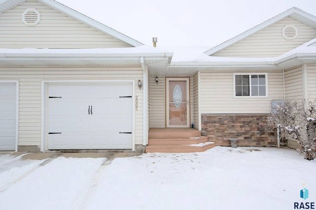 view of front of home featuring a garage and stone siding