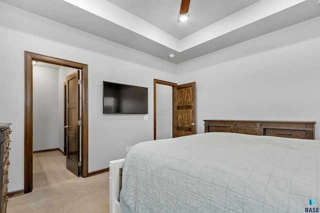 bedroom with light carpet, ceiling fan, and baseboards