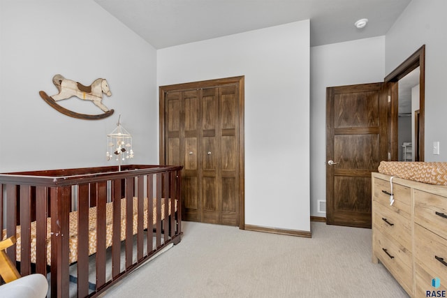 bedroom with baseboards, light carpet, and a closet