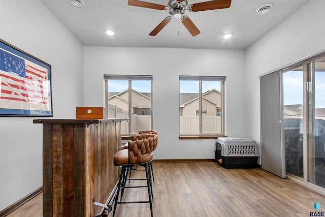 bar featuring visible vents, baseboards, recessed lighting, wood finished floors, and heating unit