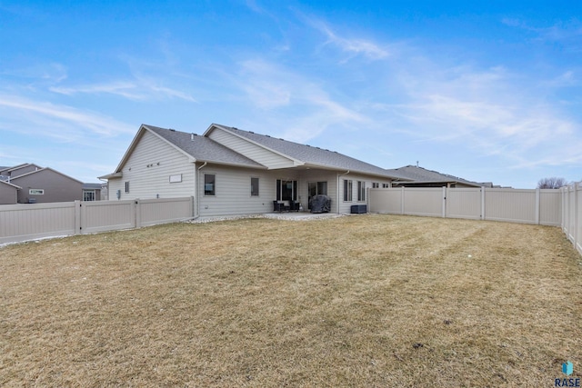 rear view of property with a fenced backyard, a patio, a yard, and a gate