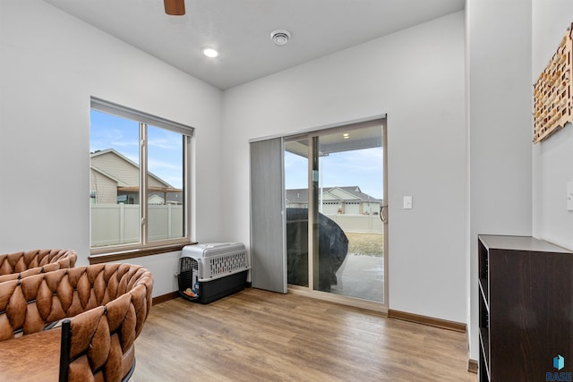 interior space featuring a wealth of natural light, baseboards, heating unit, and wood finished floors