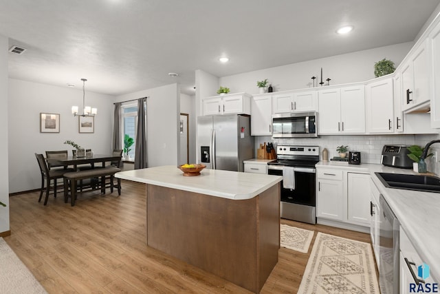 kitchen with visible vents, light wood finished floors, a sink, light countertops, and appliances with stainless steel finishes