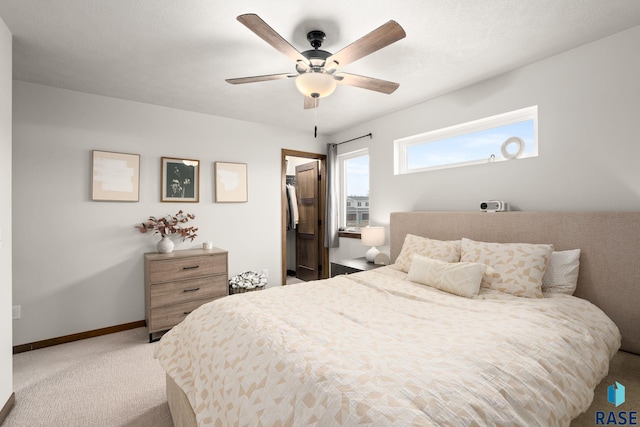 bedroom with baseboards, a spacious closet, ceiling fan, and carpet flooring