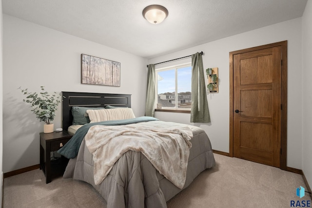 bedroom featuring light colored carpet and baseboards