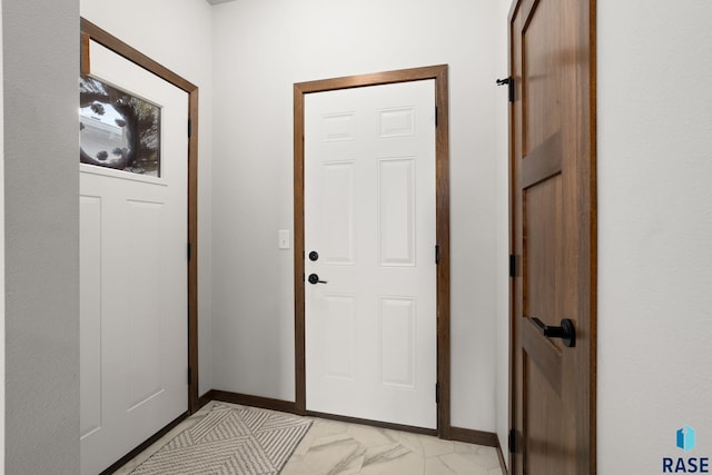 entryway featuring baseboards and marble finish floor