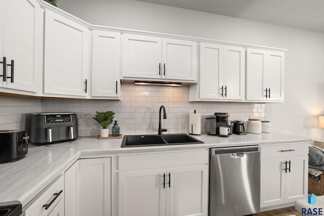 kitchen with a sink, light countertops, white cabinets, dishwasher, and tasteful backsplash