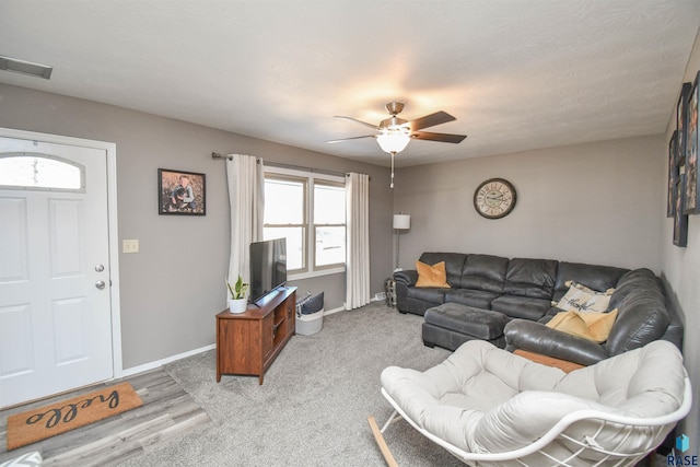 living room featuring visible vents, baseboards, and ceiling fan