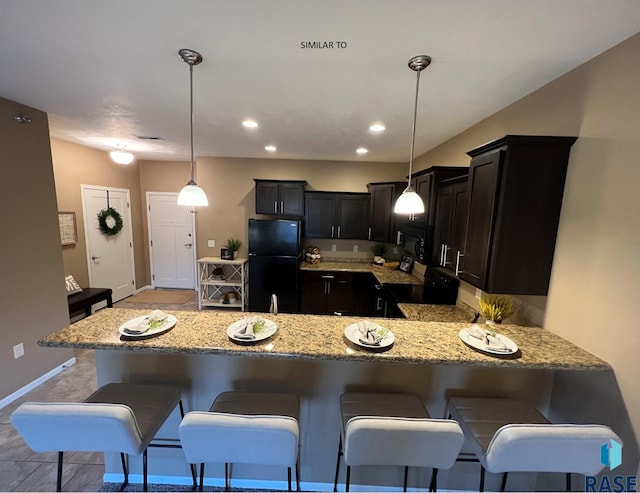 kitchen with black appliances, a breakfast bar, a peninsula, light stone countertops, and hanging light fixtures