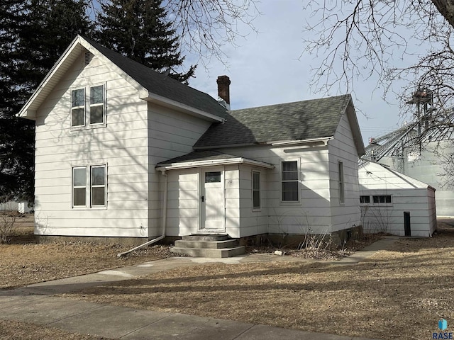 view of front of property featuring roof with shingles and a chimney