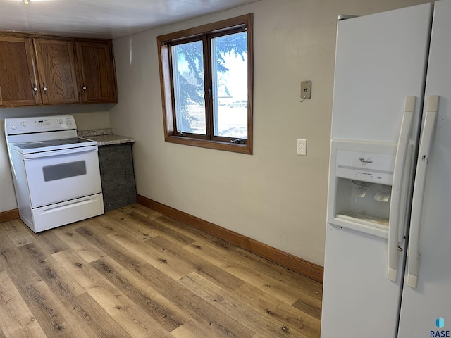 kitchen with white appliances, light countertops, light wood-type flooring, and baseboards