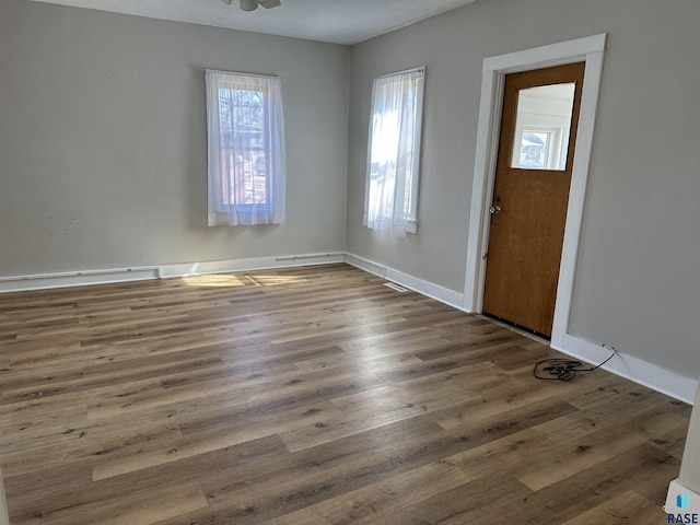 foyer featuring baseboards and wood finished floors