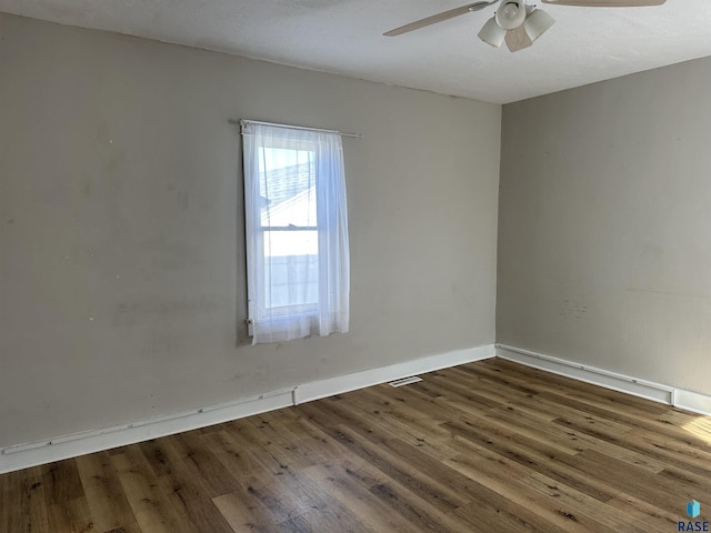 unfurnished room with baseboards, a ceiling fan, and wood finished floors