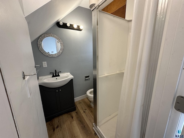 full bath featuring vanity, a shower with shower curtain, wood finished floors, vaulted ceiling, and toilet