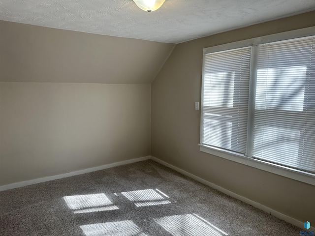 bonus room with carpet flooring, a textured ceiling, baseboards, and vaulted ceiling