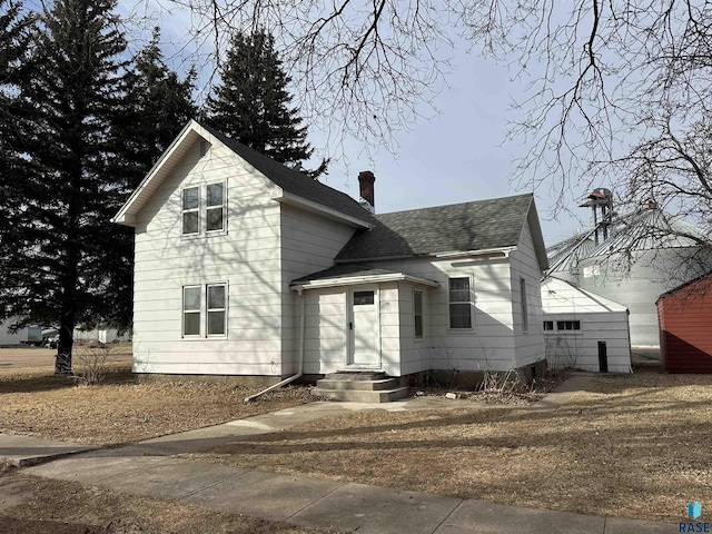 view of front of property featuring roof with shingles and a chimney