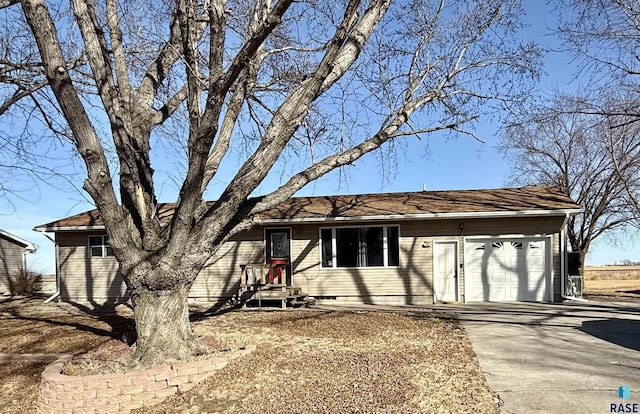 ranch-style house with concrete driveway and a garage