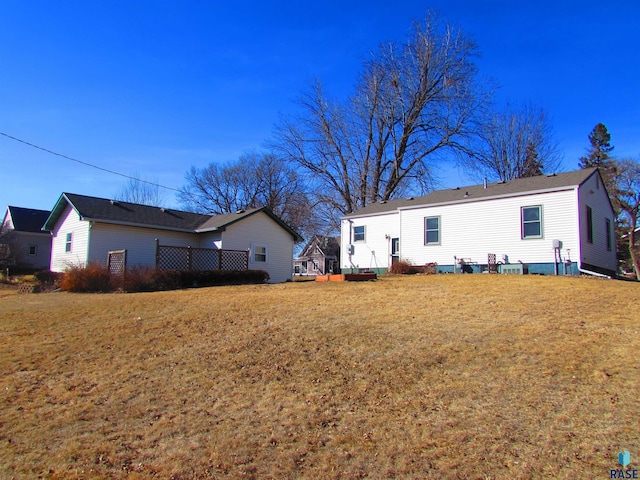 rear view of house with a yard and a wooden deck