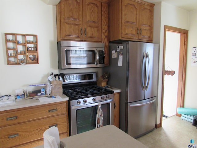 kitchen featuring brown cabinets, appliances with stainless steel finishes, light countertops, and light floors