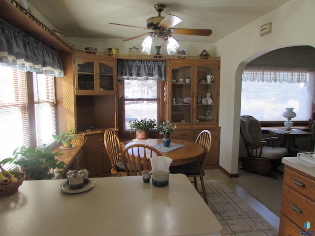 dining room with arched walkways and ceiling fan