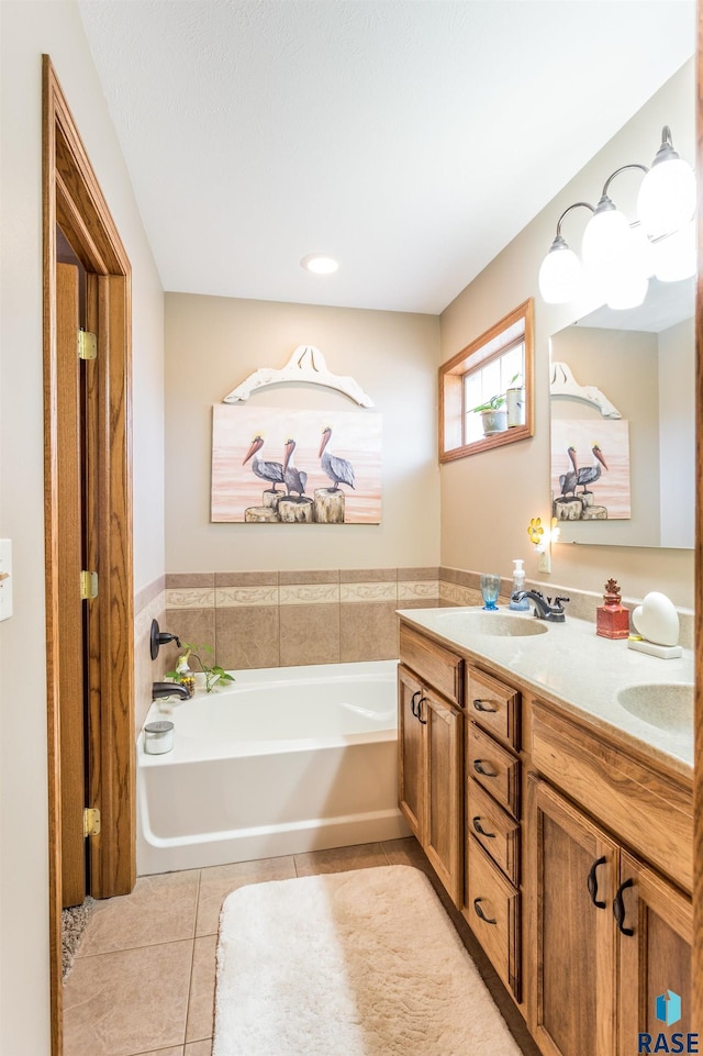 bathroom with tile patterned flooring, double vanity, a bath, and a sink