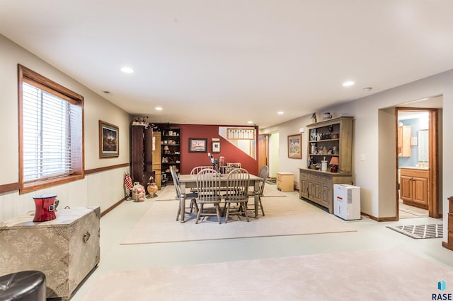 dining area with recessed lighting, a wainscoted wall, and light carpet