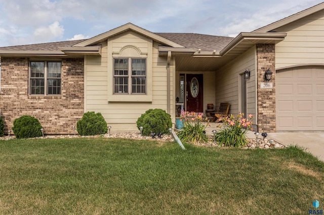 view of front of house featuring a front yard, a garage, brick siding, and roof with shingles