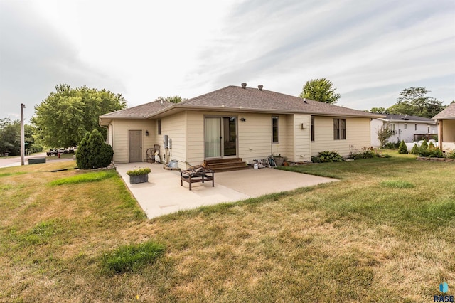 back of house featuring a lawn, entry steps, and a patio