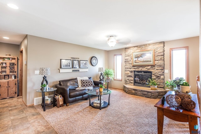 living room with a ceiling fan, a fireplace, and baseboards