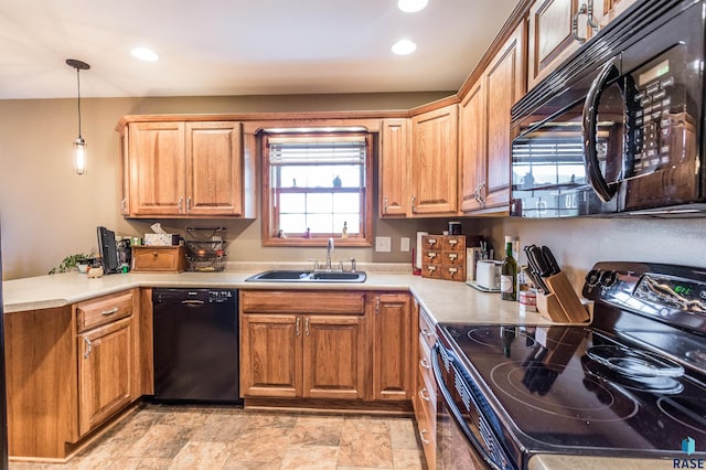 kitchen with black appliances, pendant lighting, a sink, a peninsula, and light countertops